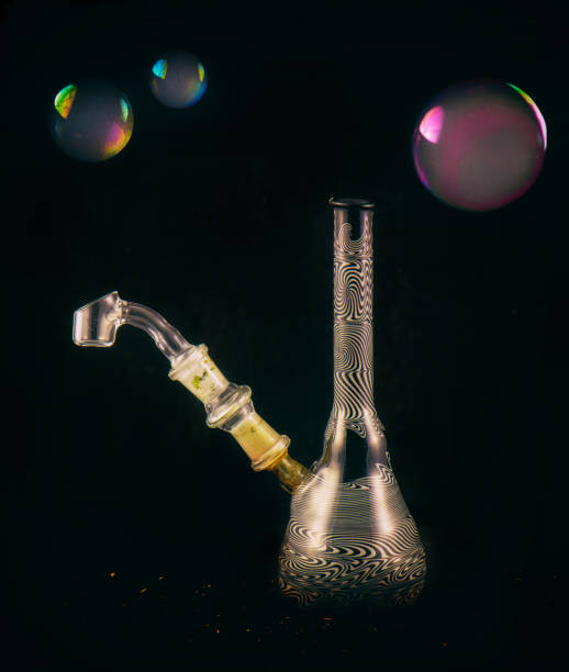 istock Dabbing glass rig with soap bubbles floating - isolated over black 857237816