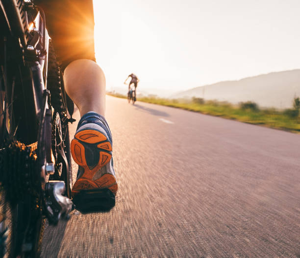 piedi sul pedale bycikle nella luce del tramonto - immagine ravvicinata - bicycle pedal foto e immagini stock