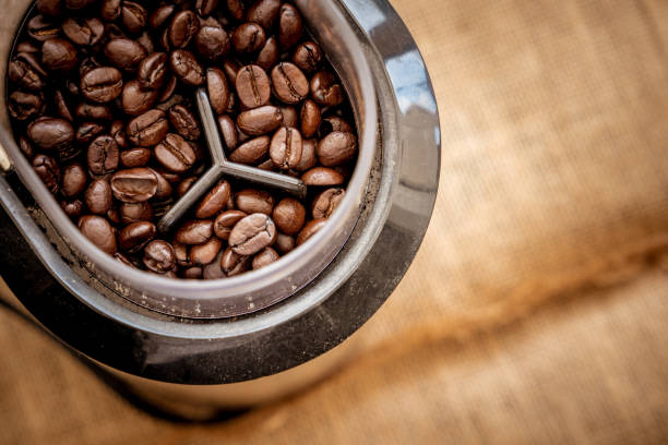 istock Coffee bean grain in a grind machine on sack fabric background 857244006
