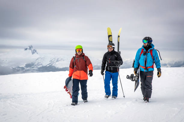 Backcountry Skier and Snowboarders on Mountain Summit Backcountry Skier and Snowboarders hiking on Mountain Summit whistler mountain stock pictures, royalty-free photos & images