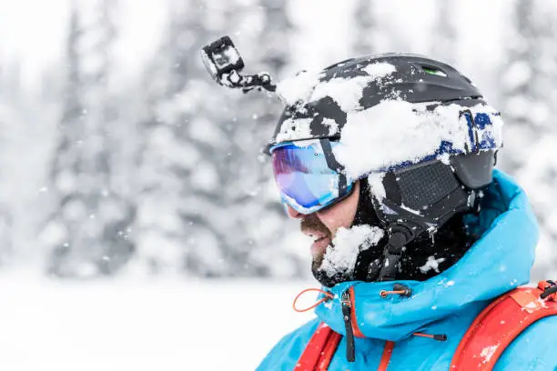 Happy Snowboarder Wearing Helmet and Goggles at The Ski Mountain