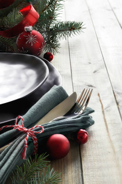 istock Christmas menu concept: black plates and cutlery with red Christmas decorations, space 857252826
