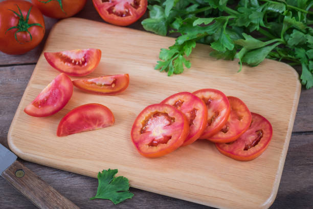 istock Tomato sliced on wooden cutting board 857253320