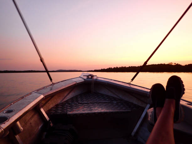 Rowboat with oars left on the shore of a lake during the summer holiday season, with sunlight. Holidays activities. This is a great way to spend your holidays actively at the lake.