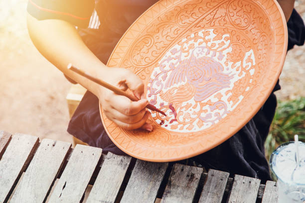 istock Artist hand painting earthenware with traditional sukhothai styel pattern handcraft pottery industry in Sukhothai Thailand vintage color tone 857260896