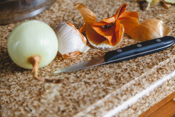 Onion husk peeled bulb and knife on marble table Onion peel small knife and peeled onion lay on a marble top riveting stock pictures, royalty-free photos & images