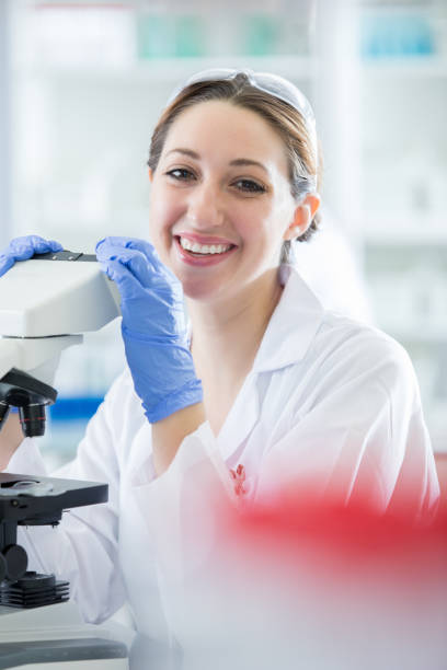 istock Portrait of a cheerful young lab technician at her microscope 857271976