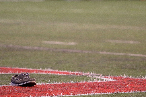 A street shoe is abandoned on an American football field during a tug of war competition