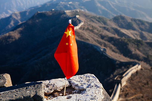 China flag waving over The Great Wall of China in the background