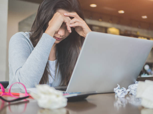 istock Young asian woman headache while sitting in a cafe with her laptop,  Stressful for work. 857281652
