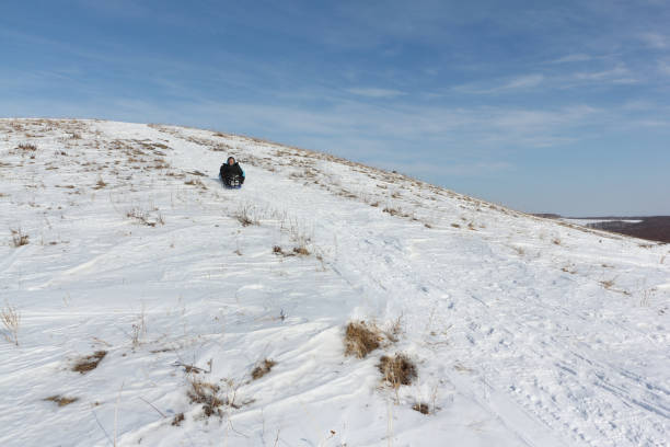 A teenager rides down a snowy hill on a tube at the Coral Pink Sand Dunes, located in Northern Arizona. December 30, 2010