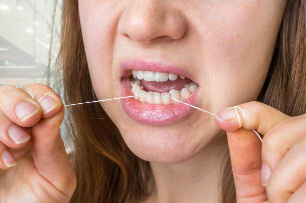 istock Woman flossing teeth with dental floss 857285462