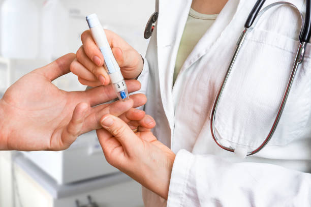 Measuring blood sugar on finger - diabetes concept stock photo
