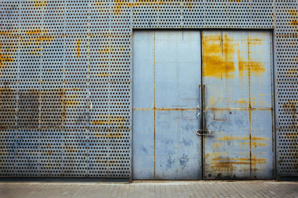 istock Rusty metal gate locked with security padlock and rusty metal wall around 857288422