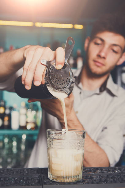istock Young bartender pouring cocktail drink into glass 857289090