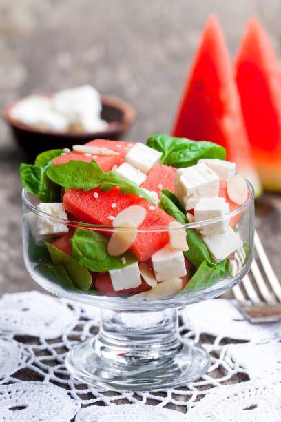 salade de melon d’eau fraîche et feta avec des feuilles de basilic et épinards - doily freshness raw sweet food photos et images de collection