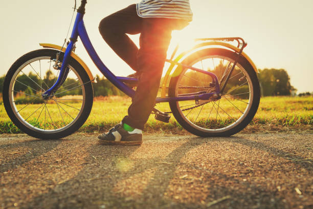 istock little boy riding bike at sunset 857289742