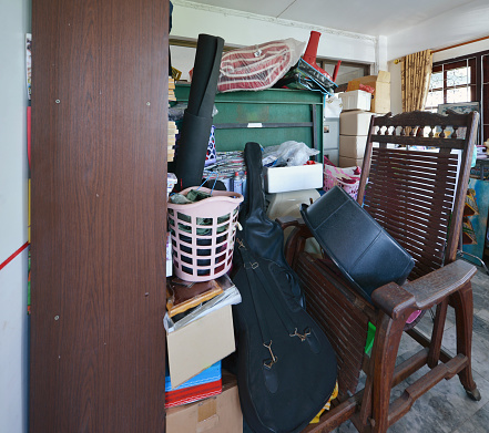 Messy storage room in garage for junk in old house