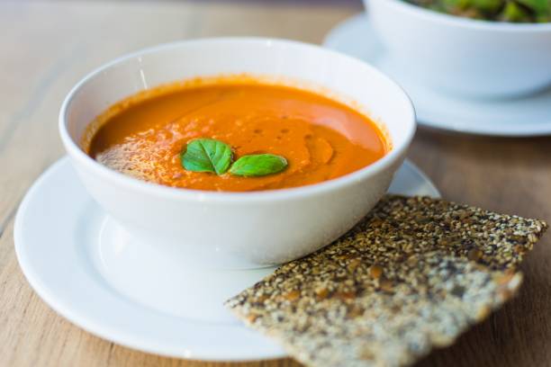 frische, cremige tomatensuppe mit basilikum - tomato soup red basil table stock-fotos und bilder