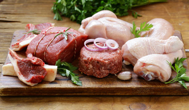 istock raw meat assortment - beef, lamb, chicken on a wooden board 857309024