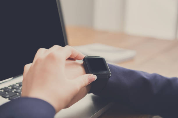 istock Close-up of woman using smart watch at workplace 857309334