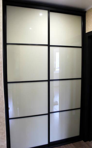 istock Brown wardrobe with white glass sliding doors 857313826