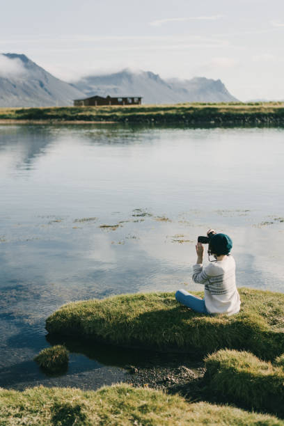 Woman  taking photo on the beach in Iceland Young Caucasian woman taking photo  on the beach in Iceland beautiful multi colored tranquil scene enjoyment stock pictures, royalty-free photos & images