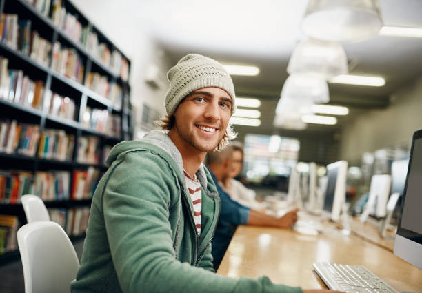 Cropped portrait of a young male university student studying in the library