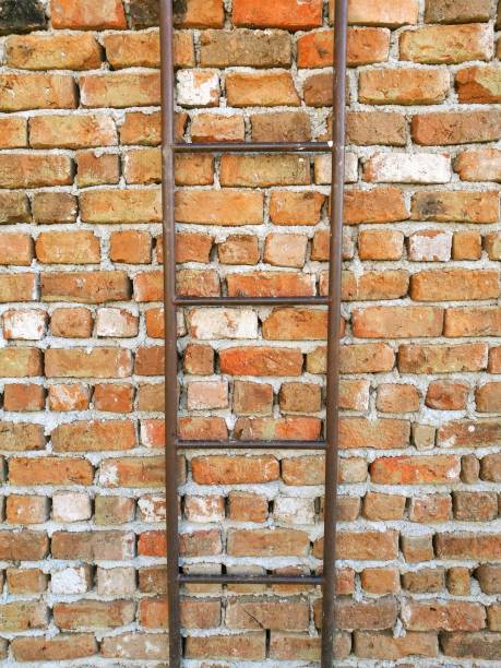 istock brick wall with a hanging iron ladder 857326592