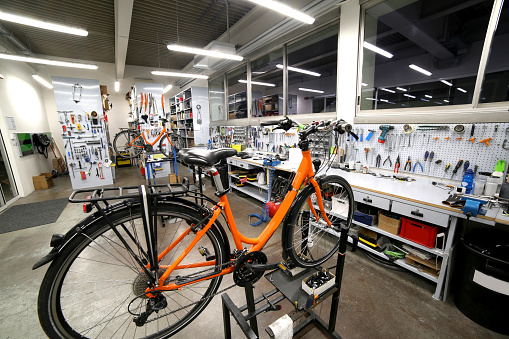 Orange broken  bicycle in the mechanical workshop for repair