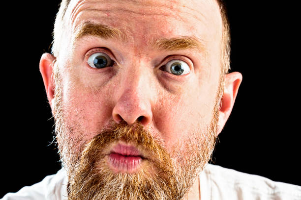istock Bearded man with wide eyes, raised eyebrows and pursed lips 857332184