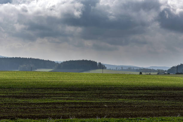 istock green field in foreground forests on hills under dark clouds 857333534