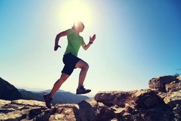 istock woman trail runner running at mountain top 857334080
