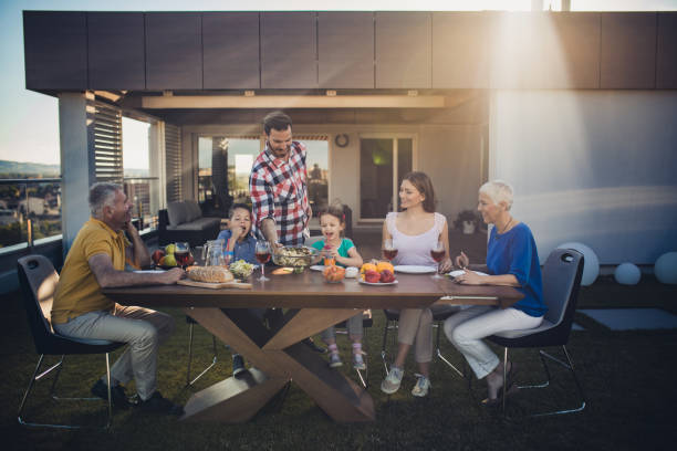 istock Happy multi-generation family having a meal on a penthouse balcony. 857348280