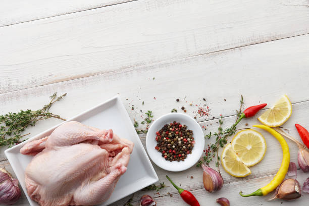 istock Raw chicken, herbs and spices on white wooden background 857348948