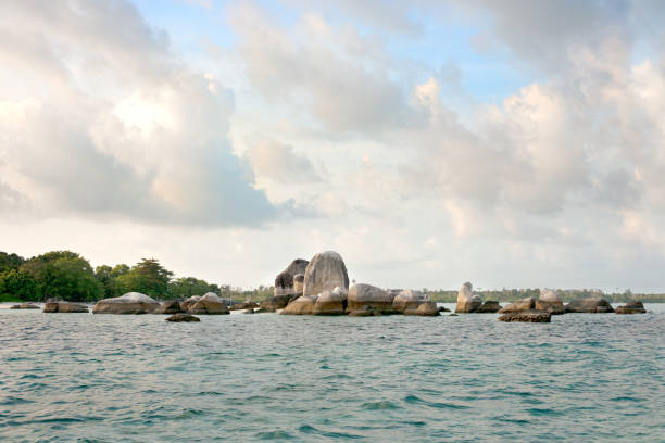 Natural granite rock formation placed in the ocean next to white sand beach  in the morning Belitung Island Indonesia.