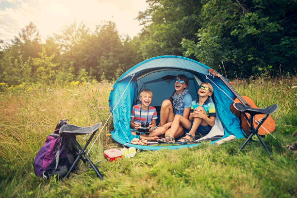 istock Kids having fun camping in tent on the forest meadow 857361720