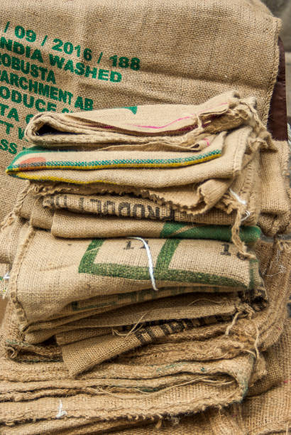 istock many empty coffee beans bags folded and lying on a pile a sack hangs in the background with non-saying partial print 857368500
