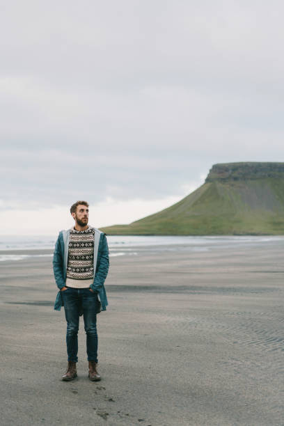 istock Man  walking on the beach in Iceland 857370528