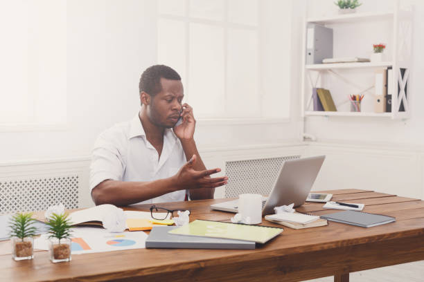 istock Young black businessman call mobile phone in modern white office 857370600