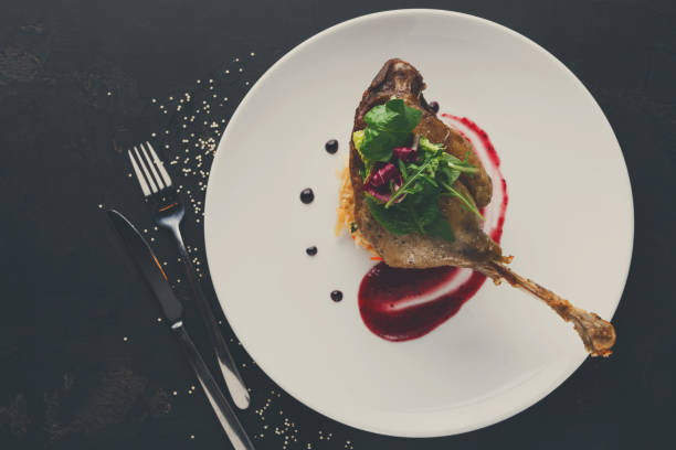 istock Restaurant meals. Duck confit with vegetables on black backgroun 857378100