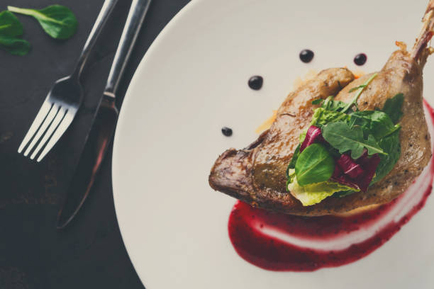istock Restaurant meals. Duck confit with vegetables on black backgroun 857380244