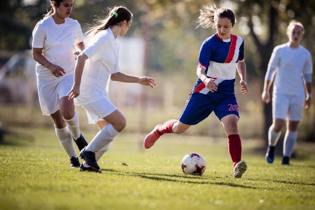istock Teenage soccer player avoiding her opponents on a match. 857392398