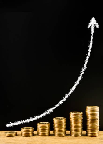 istock Money coin stack arranged as a graph on a wooden and draw arrow with chalk on blackboard, concept of money growth 857397200