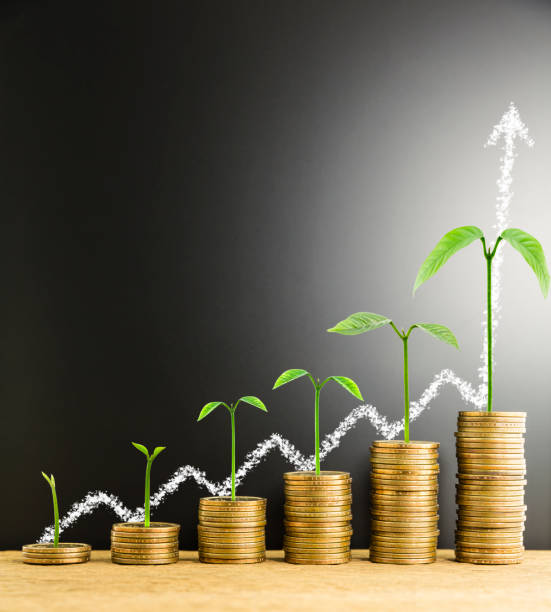 istock Stack of money coin arranged as a graph on wood with tree growth and write white chalk arrow indicates economic upturn on blackboard the scene behind, concept of money growth 857399426