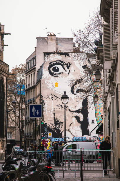 peintures murales et les gens à paris, en france - graffiti paintings men walking photos et images de collection