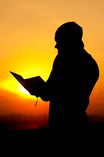 istock Silhoette of relaxed man reading a book at sunset 857404428