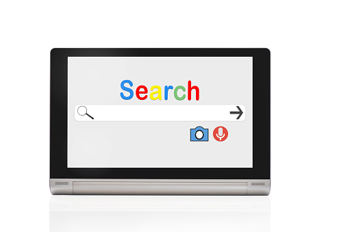 Search engine website on computer tablet screen with search by image and voice icon on white background
