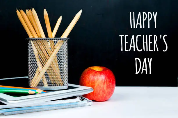 happy teacher's day, chalk greetings on black board in classroom
