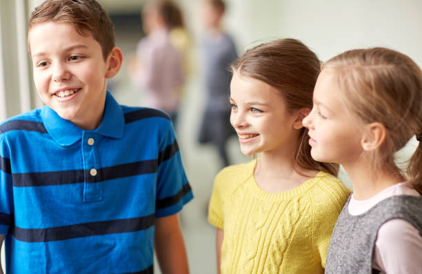 istock group of smiling school kids talking in corridor 857419114